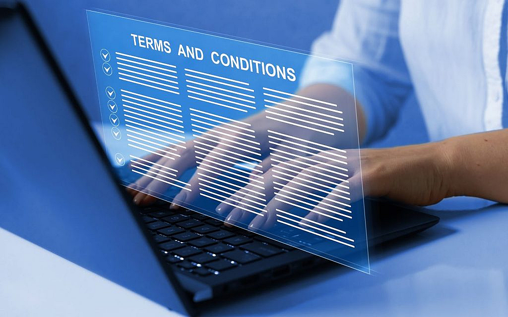  Digital contract displayed on a laptop screen showing working conditions, placed on a clean desk. 