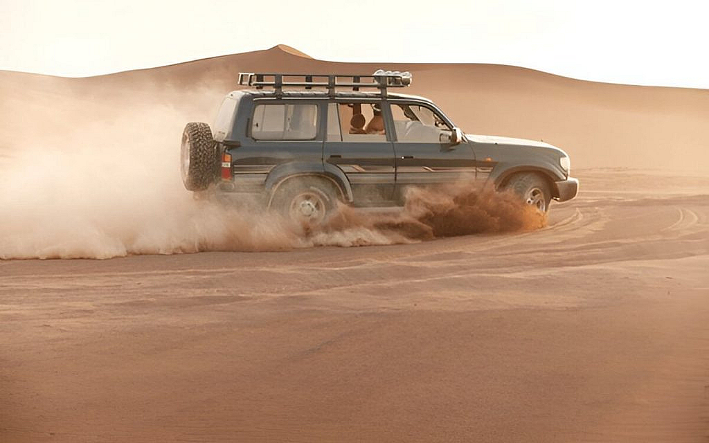 A standard off-raoder crossing through a desert