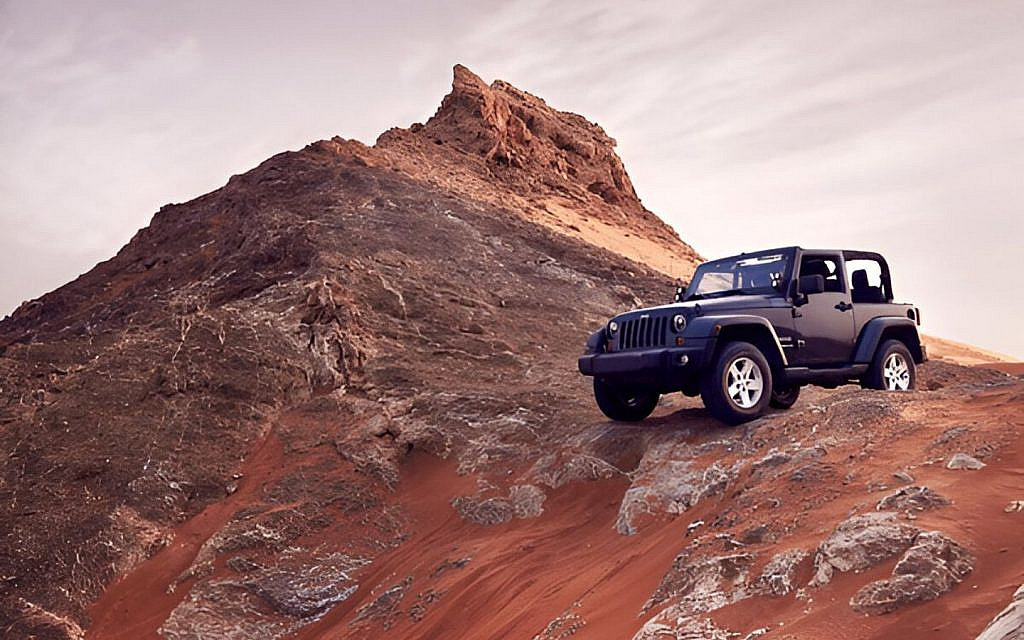 Blue colour off roader at the edge of a mountain
