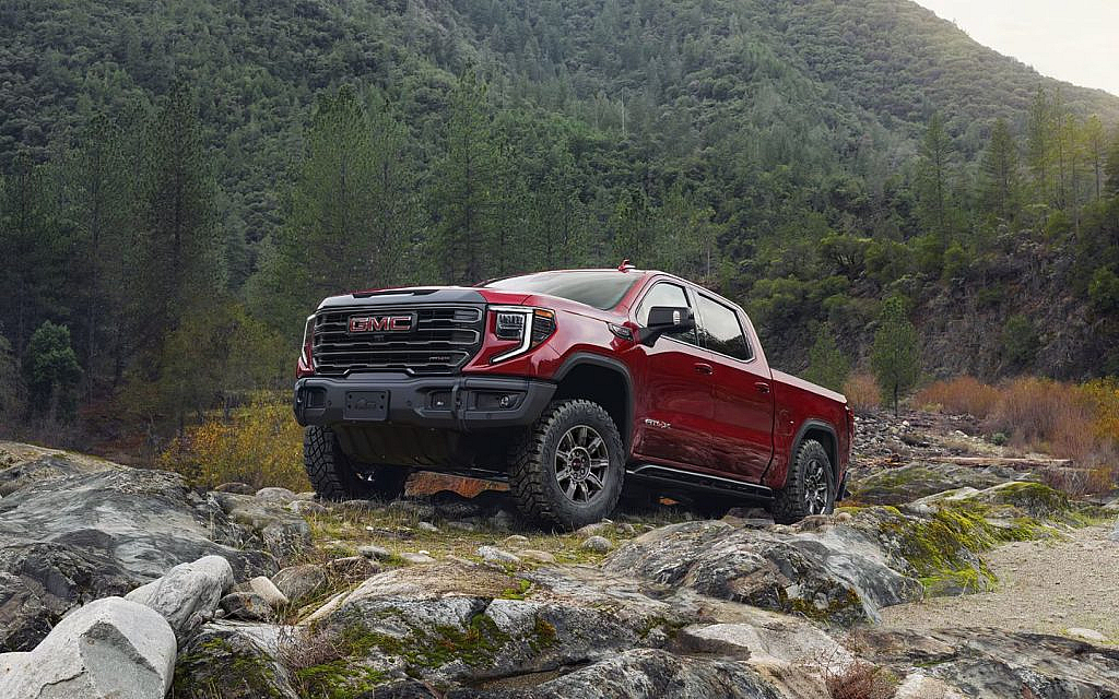 Red colour 2025 GMC Sierra over a hilly mountain