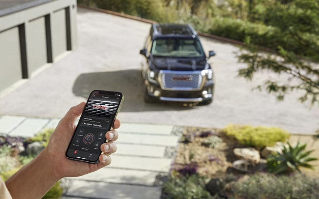 Driver using myGMC App to turn the engine of black yukon 