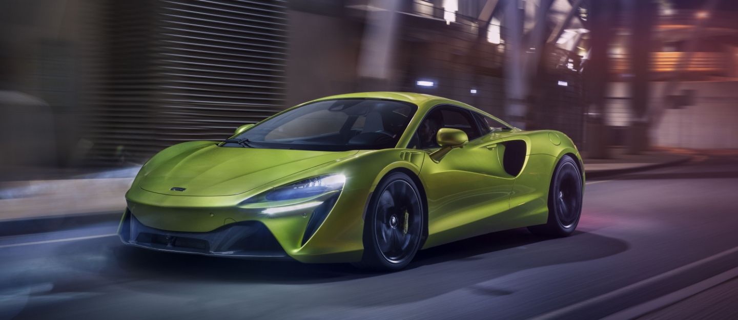 Vibrant lime green McLaren Artura sports car driving, highlighting interesting facts about the McLaren Artura.