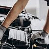 A Mechanic's gloved hands working on a car engine, illustrating vehicle low maintenance.