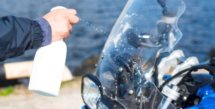 man cleaning bike's windshield