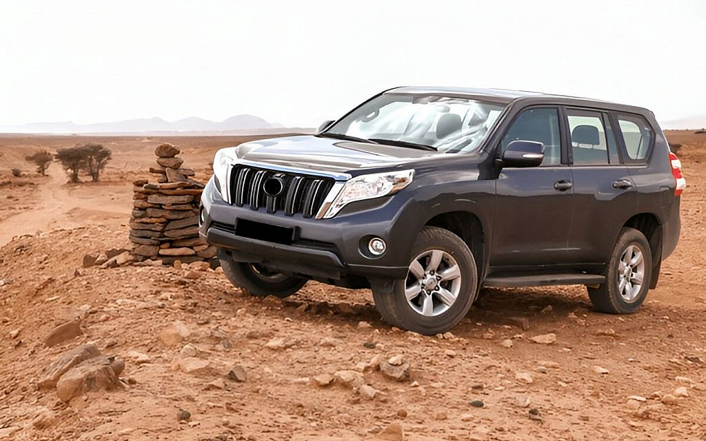 A luxury SUV parked on a rocky terrain