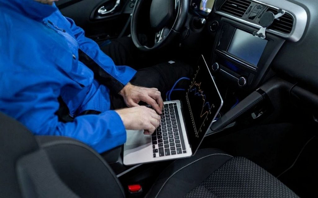 A mechanic inspecting a rental car through a computer