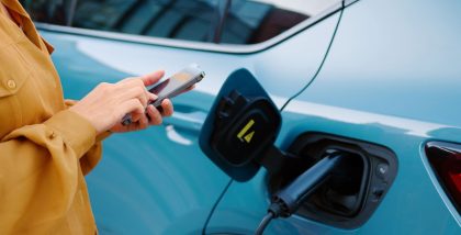 female using mobile at a petrol station