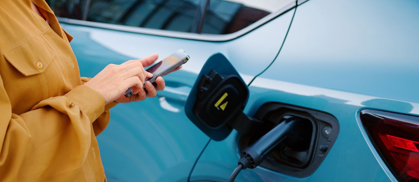 female using mobile at a petrol station