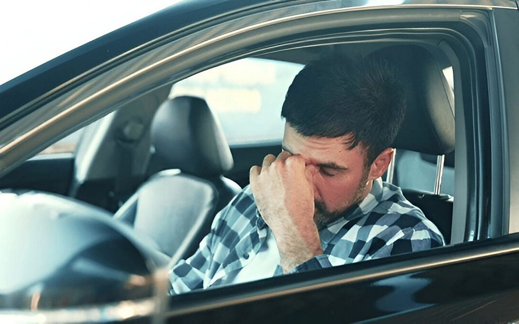 A tired driver stuck in a traffic jam