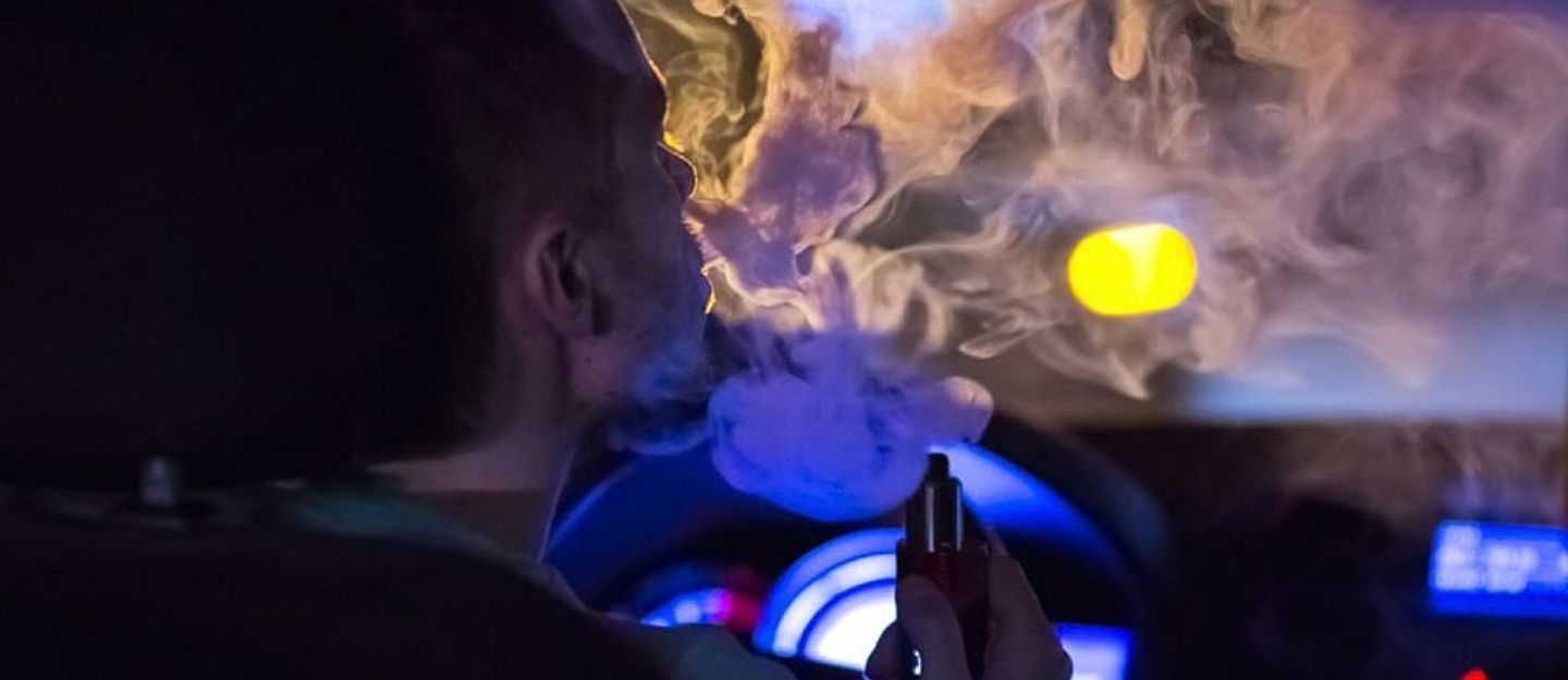 man vaping in car