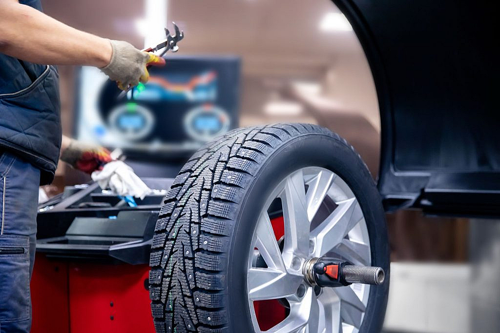 شخص يفحص إطار السيارة