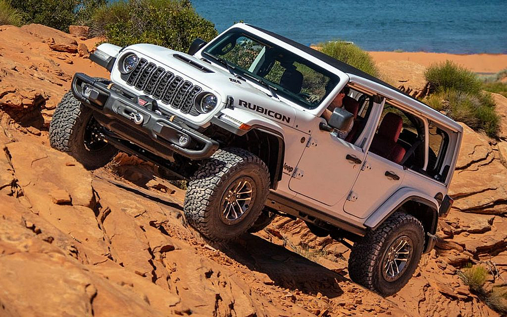 White Jeep Wrangler crossing a rocky terrain