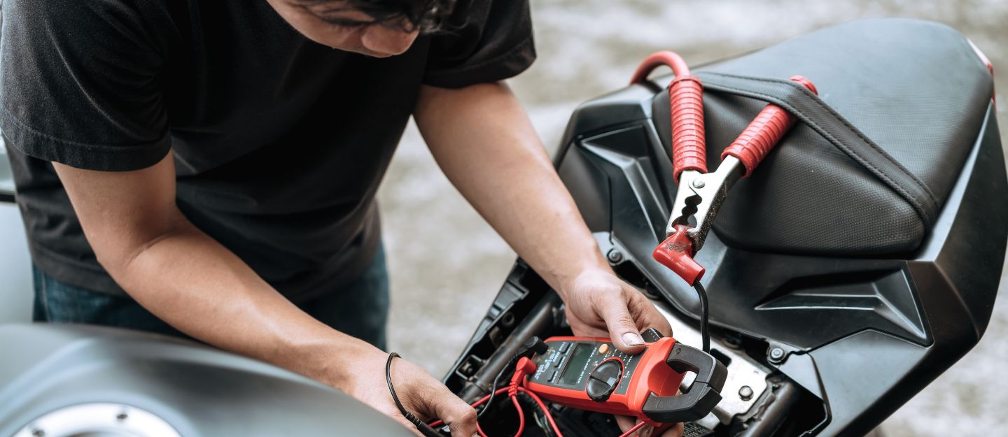 a person installing a motorcycle GPS tracker