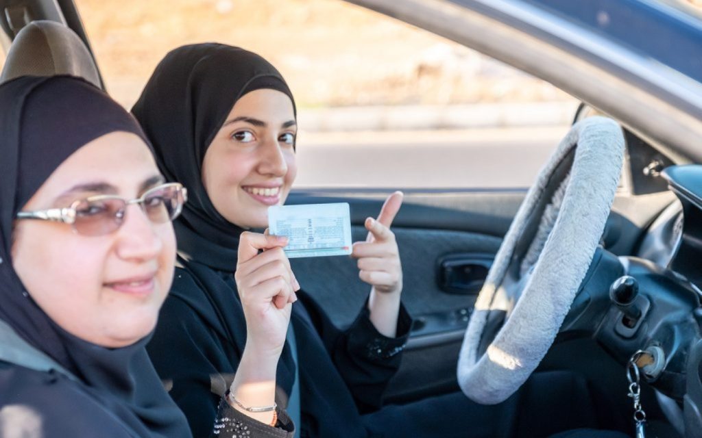 سائقة تمسك برخصة قيادة