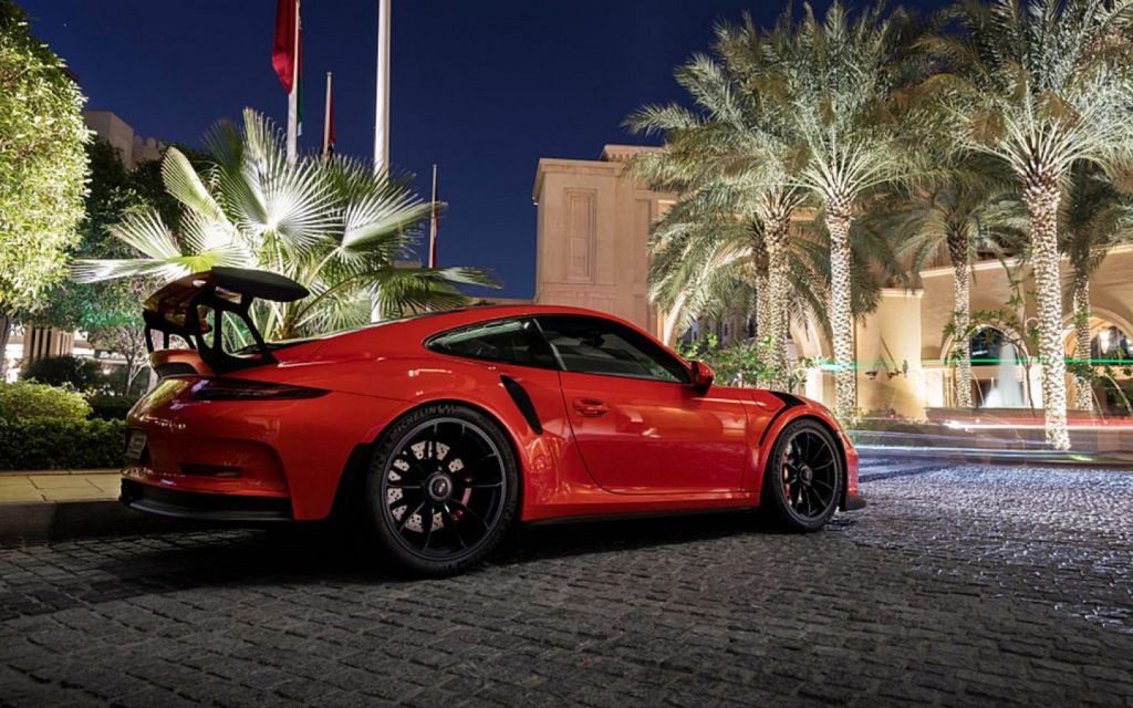 Red colour sports car with a spoiler