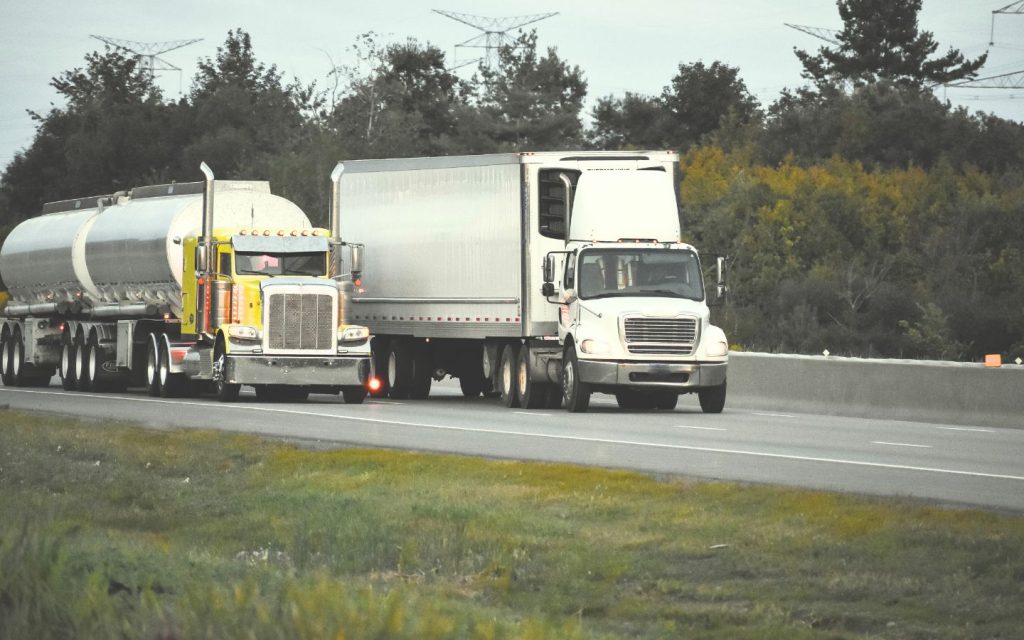 Two trucks driving on a street