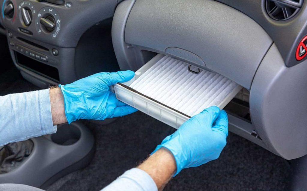 A mechanic installing a cabin air filter