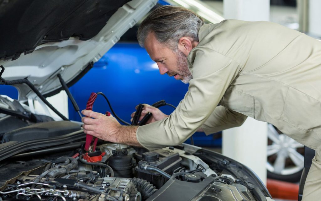 A mechanic fixing a damaged car battery