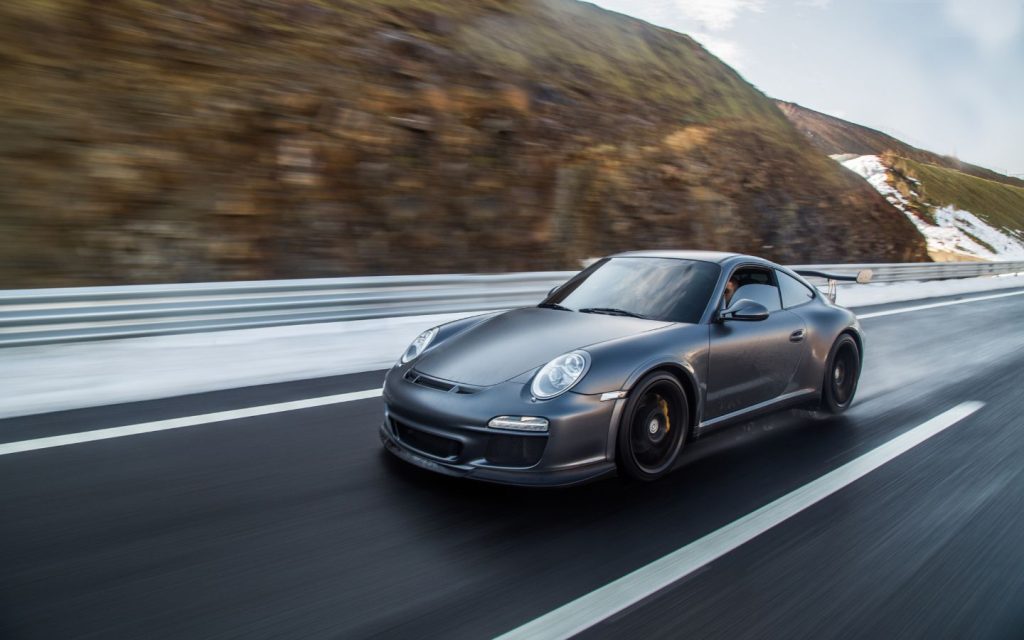 Grey supercar on a hilly road