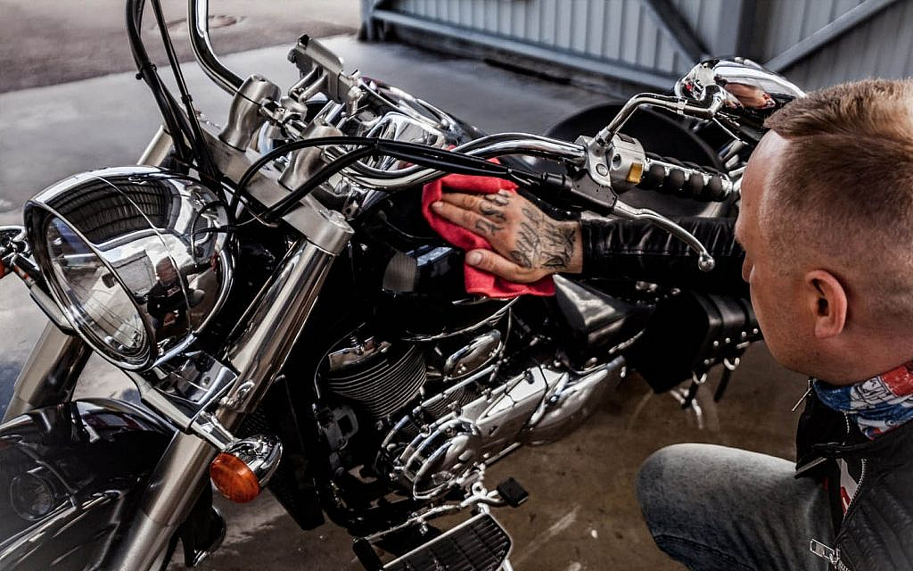 Man cleaning his bike during a motorcycle service in Dubai