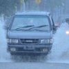 Car driving through a flooded road during heavy rain