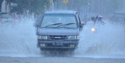 Car driving through a flooded road during heavy rain