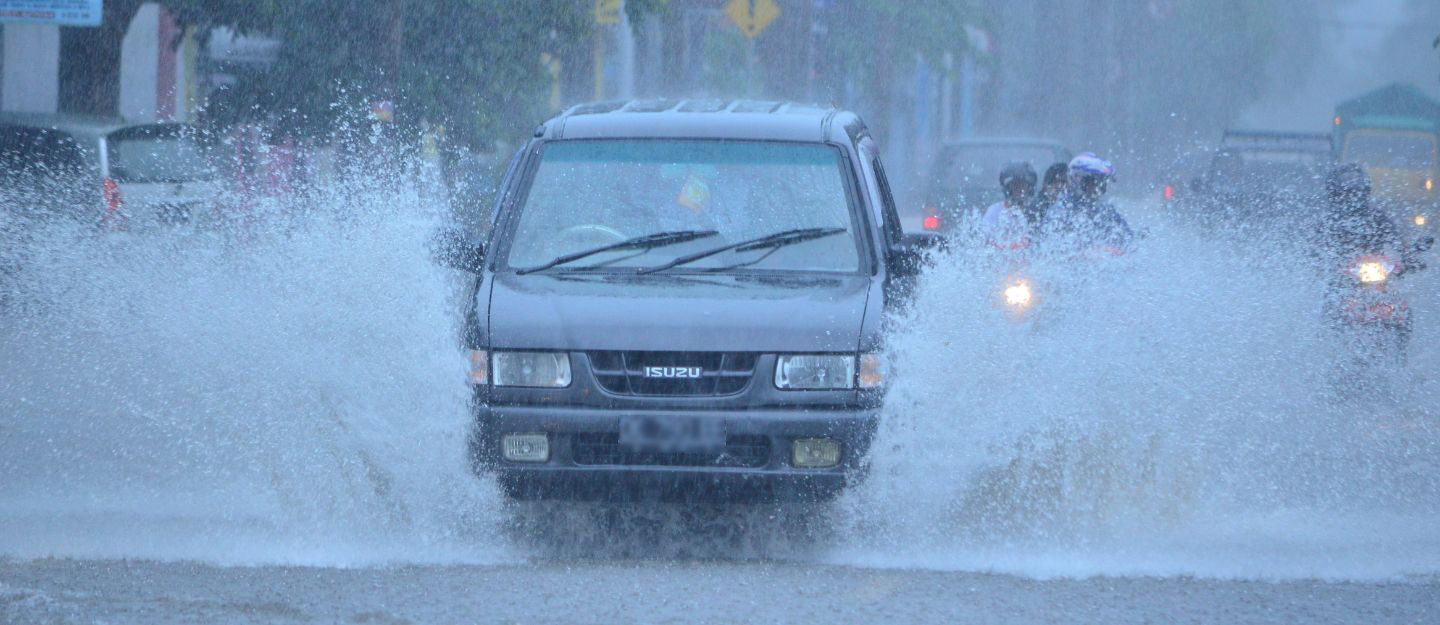 Car driving through a flooded road during heavy rain
