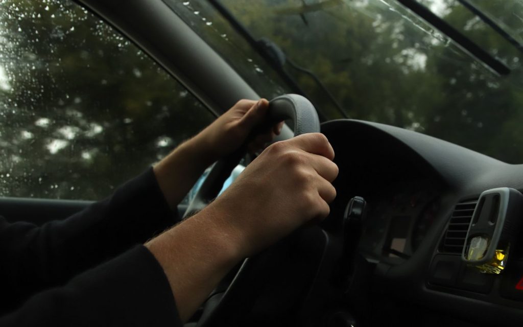 man driving while getting Dubai rta real time alerts for rain roads