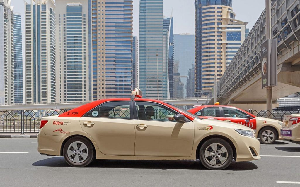 beige coloured Dubai taxi on the road