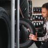 man checking different types of racing tyres in a showroom