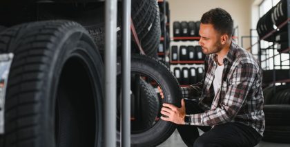 man checking different types of racing tyres in a showroom