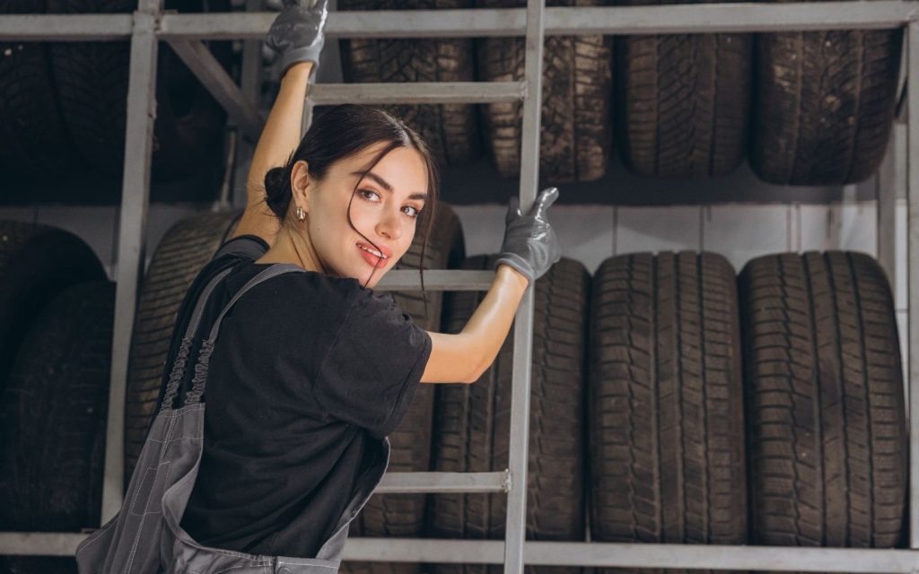 woman checking different types of racing tyres for cars