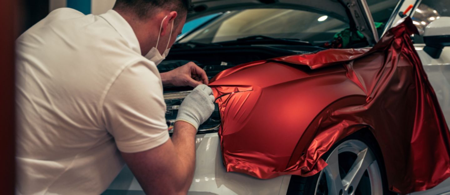 A mechanic is applying different types of car wraps