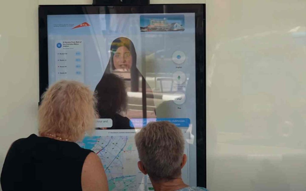 two people checking bus routes on screen