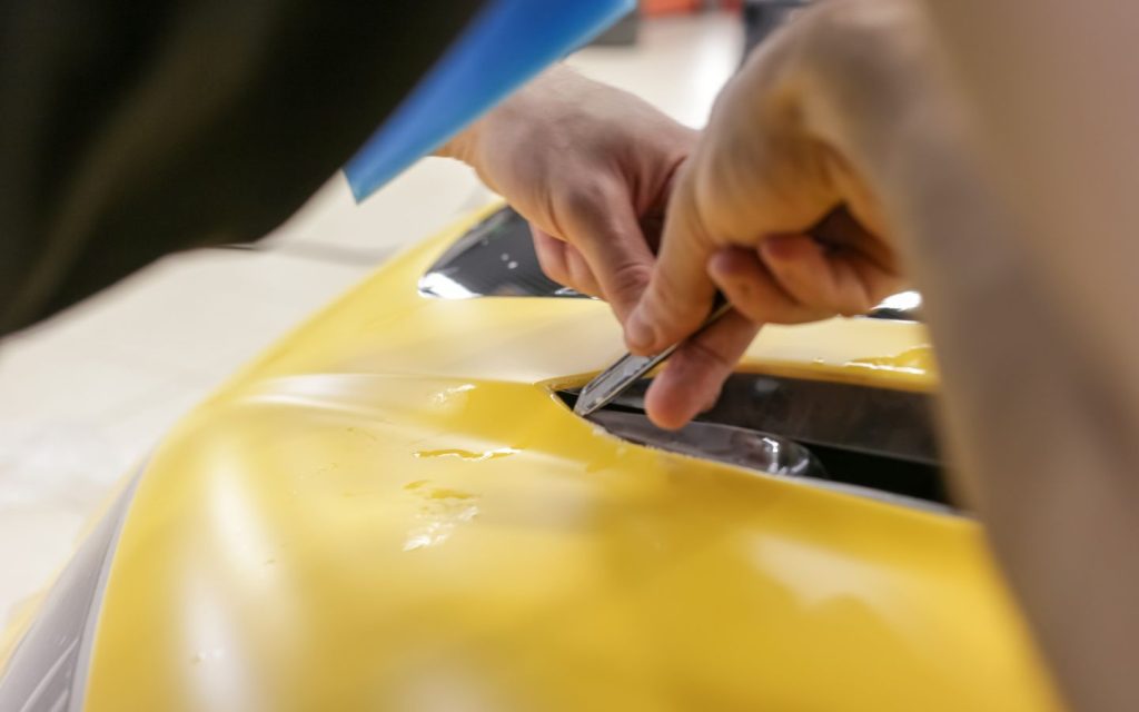 a person is working with self-healing car paint technology 
