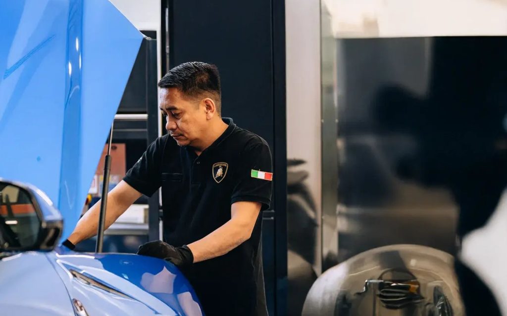A professional Lamborghini technician dressed in black.