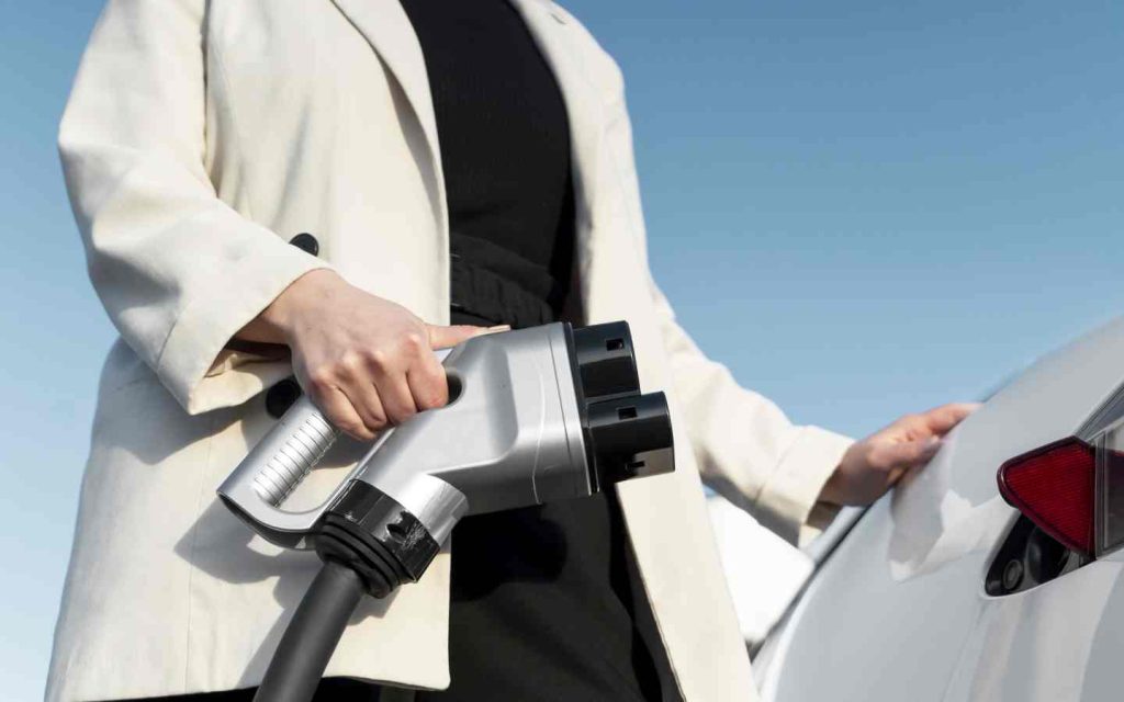 woman holding EV charging port