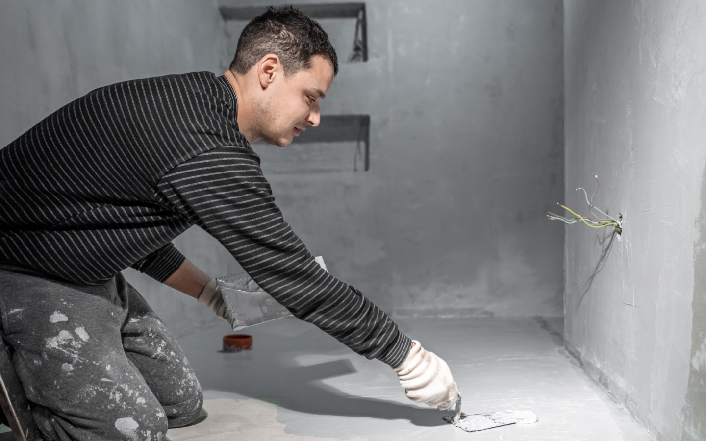 عامل يدهن الطبقة الأساسية لعزل حمام ضد الماء