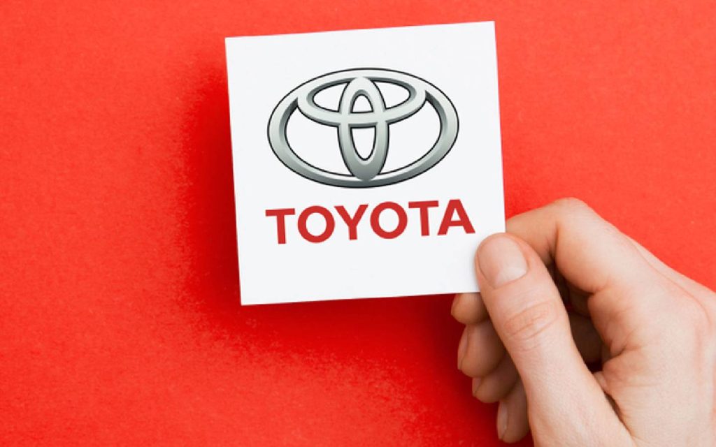 A logo in a person’s hand representing the history of Toyota in Japan and the rest of the world