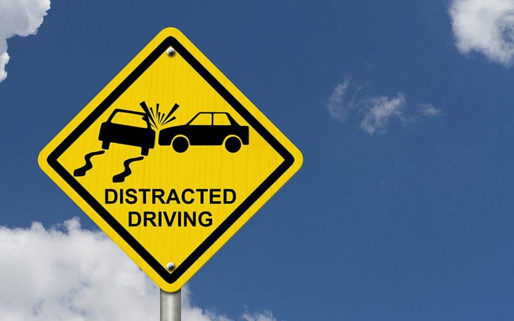 A signboard with distracted driving warning for road safety