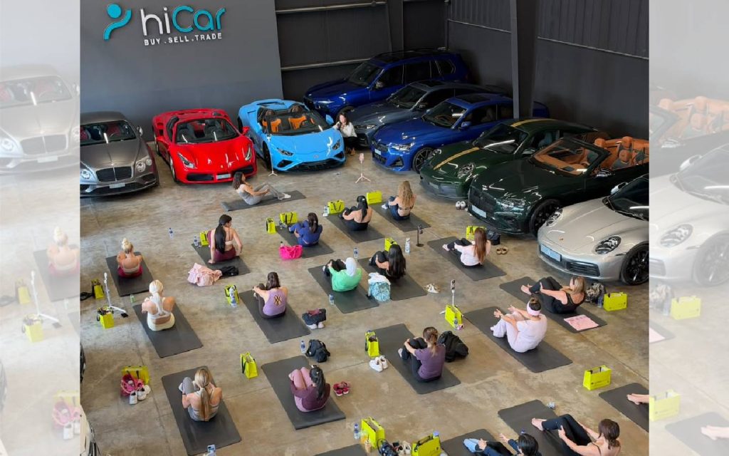 women performing yoga in a car dealership in Dubai